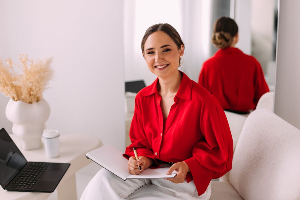 Viktorija Garanca writing in a notebook at a white desk